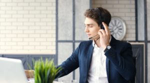 Customer service agent using headset at laptop