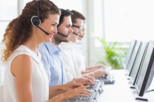 Call center agents wearing headsets at computers