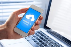 Hand holding smartphone with cloud upload screen